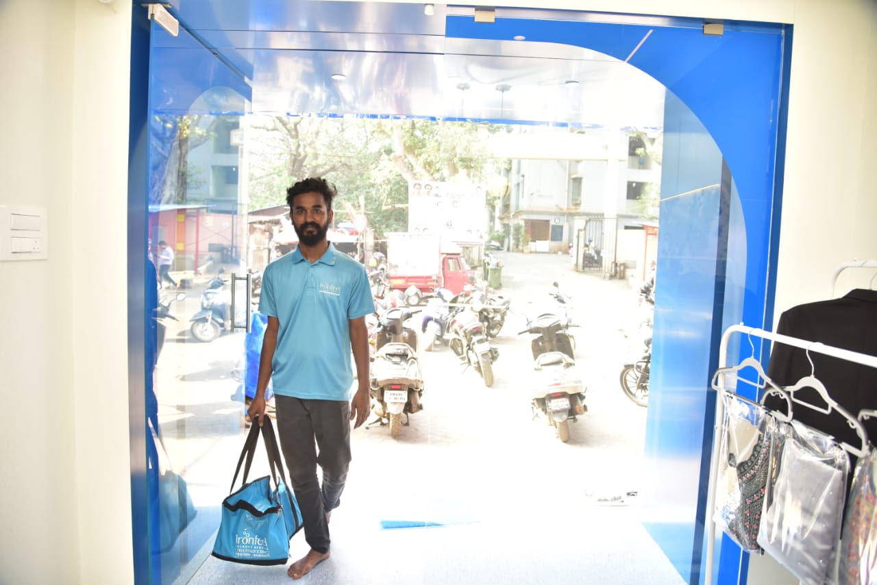 Inside the IronFeel laundry facility with industrial washing machines and fresh garments